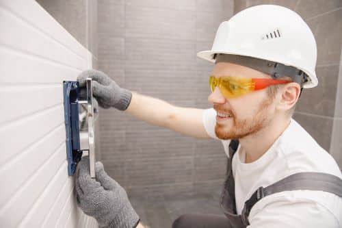 Plombier Corbas - Un plombier installe installe un radiateur.