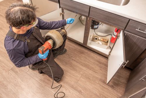 Plombier Feyzin - Un plombier fait des travaux dans une cuisine.