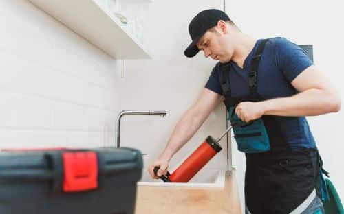 Plombier Gruson - Un plombier effectue un débouchage dans un évier dans cuisine