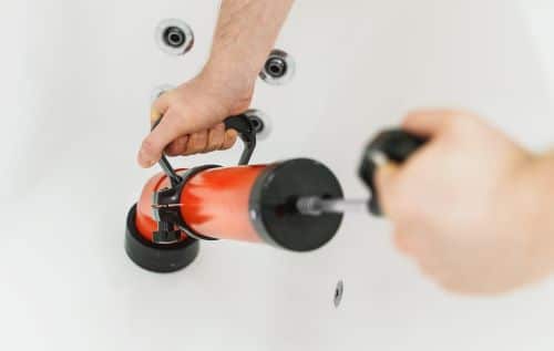 Plombier Linselles - Un plombier débouche une baignoire