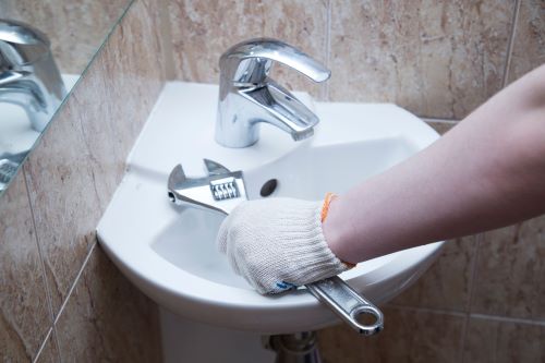 Plombier Pérenchies - Un plombier installe un lavabo