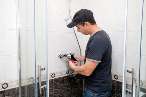 Plombier Ronchin - Un plombier installe un robinet de douche