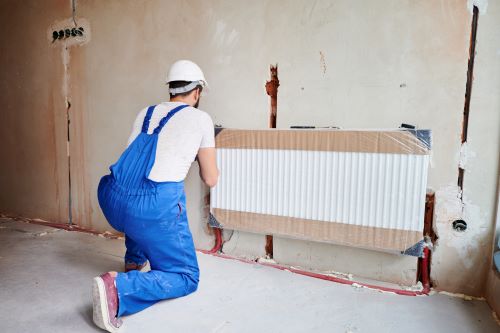 Plombier Sainghin-en-Mélantois - Un plombier chauffagiste installe un chauffage au mur