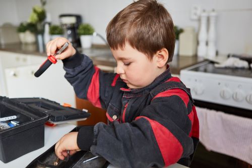 Plombier Vitrolles - Un enfant tient les outils du plombier