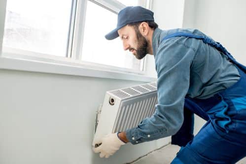 chauffagiste Cherbourg-en-Cotentin - un plombier chauffagiste installe un radiateur