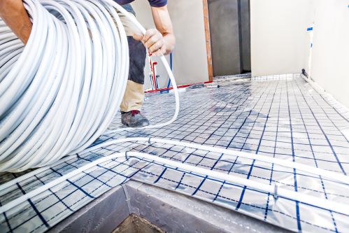 chauffagiste Hyères - un homme installe un plancher chauffant