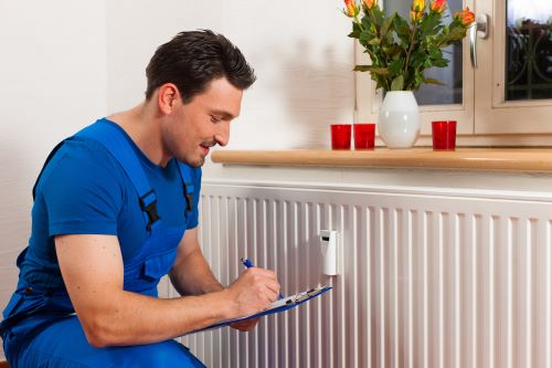 chauffagiste Rueil-Malmaison - un plombier chauffagiste règle un radiateur