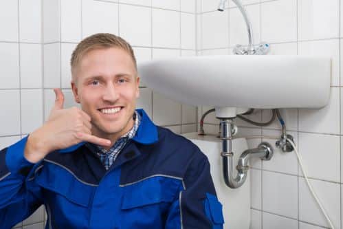 plombier Deûlémont - un plombier chauffagiste prend la pose dans une salle de bains
