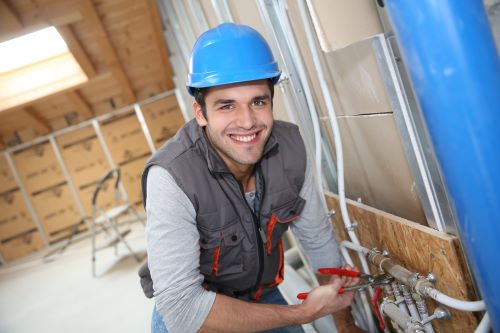 plombier Houplines - un homme installe un circuit d'eau dans une maison neuve