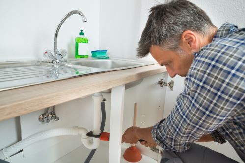 plombier Loos - un homme débouche un siphon d'évier