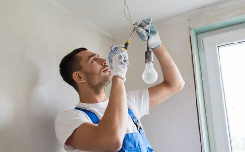 Électricien Alfortville - Un artisan installe des ampoules.