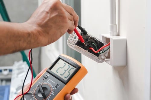 Électricien Châteauroux - Un électricien mesure le voltage d'une prise