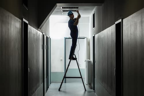 Électricien Mantes-la-Jolie - Un électricien fait une installation au plafond