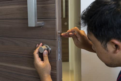 Serrurier Dijon - Un serrurier fixe n verrou sur une porte de salle de bain