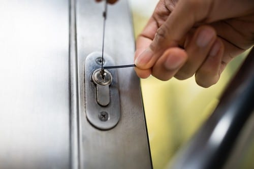 Serrurier Évreux - Un serrurier tente d'ouvrir une porte à l'aide d'un crochet