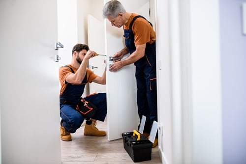 Serrurier Narbonne - Deux artisans installe une serrure sur une porte.