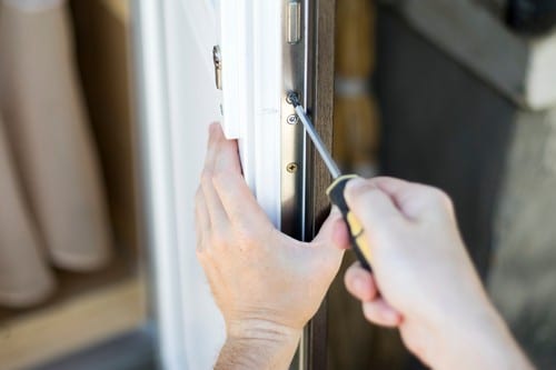 Serrurier Niort - Un serrurier répare et installe une serrure sur une porte en plastique