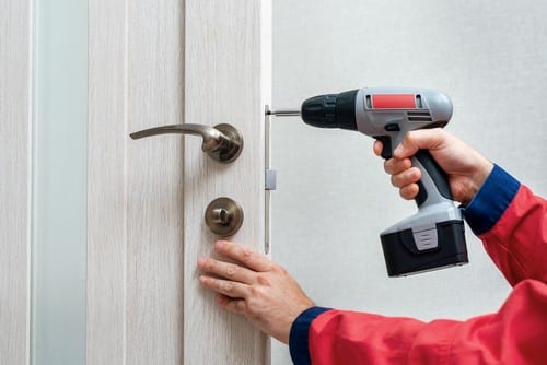 Serrurier Pessac - Un serrurier installe une poignée de porte.