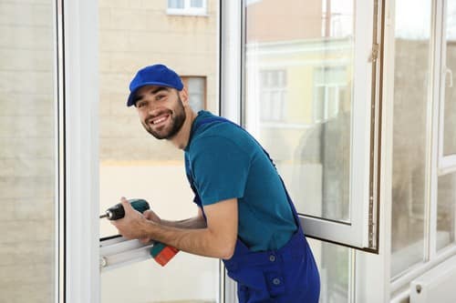 Vitrier Le Blanc-Mesnil - Un serrurier utilise une perceuse pour installer une fenêtre.