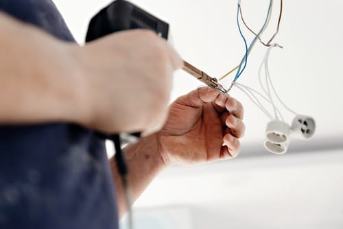 électricien Suresnes - un homme installe une prise électrique