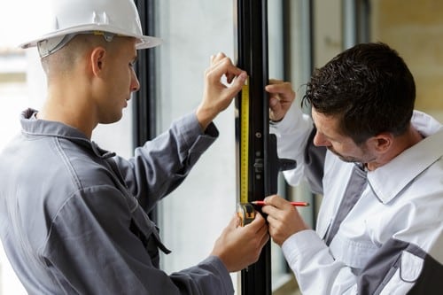 serrurier Épinay-sur-Seine - deux artisans inspectent une porte vitrée