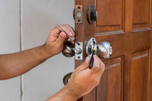 serrurier Mérignac - un artisan travaille sur une porte en bois