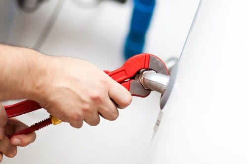 Chauffagiste Ambarès-et-Lagrave - Un technicien répare un chauffe-eau.