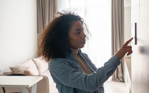 Chauffagiste Mons-en-Barœul - Une femme utilise son thermostat