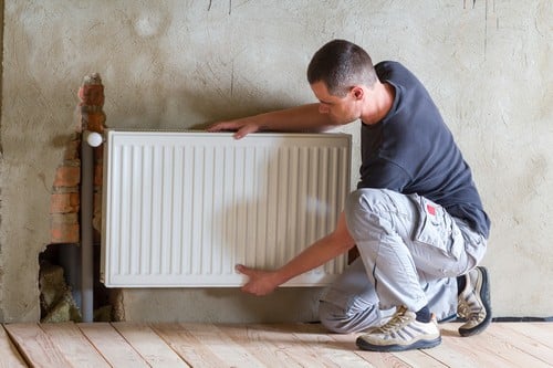 Chauffagiste Tassin-la-Demi-Lune - Un chauffagiste installe un radiateur.