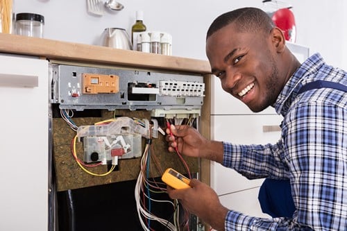 Électricien Auriol - Un électricien répare un lave-vaisselle.