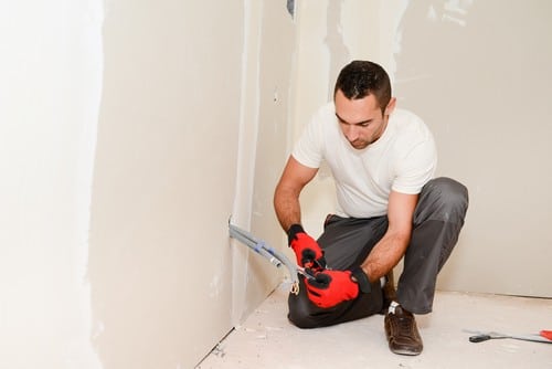 Électricien Carvin - Un électricien installe le réseau électrique d'une maison en construction.