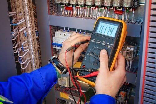 Électricien Colomiers - Un électricien teste le voltage d'un panneau électrique