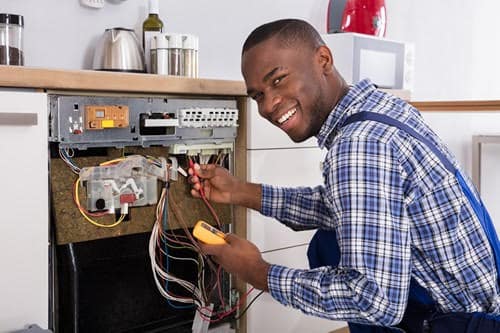 Électricien Eysines 1 - Un artisan répare un lave-vaisselle.