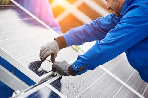 Un électricien installe un panneau solaire