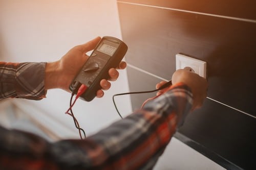 Électricien Gardanne - Un électricien mesure la tension électrique d'une prise.