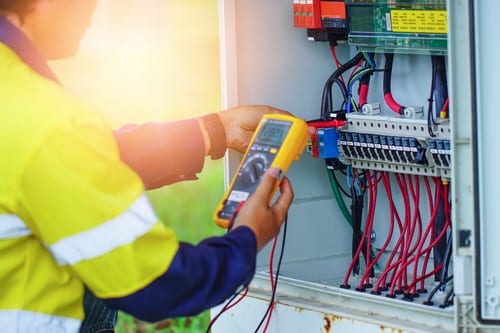 Électricien Marquette-lez-Lille - Un électricien utilise un multimètre pour mesurer le voltage d'un panneau électrique