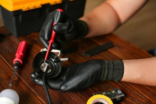 Électricien Meyzieu - Un électricien répare une prise électrique
