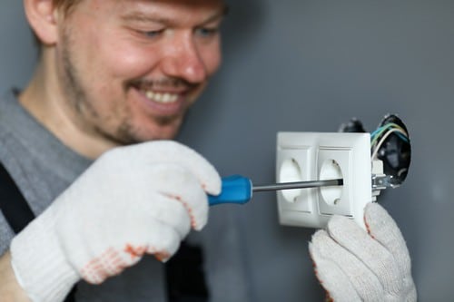 Électricien Monteux - Gros plan sur un électricien en train d'installer des prises électriques.