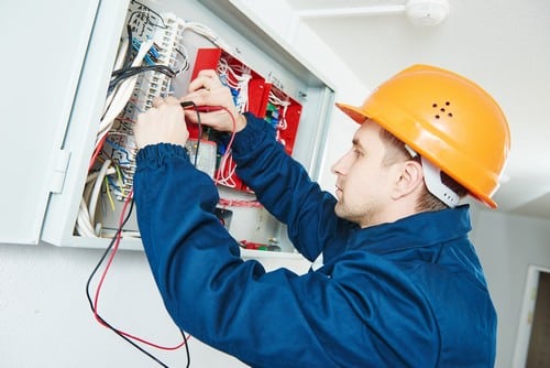 Électricien Oignies - Un électricien répare un tableau électrique.