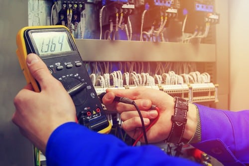 Électricien Rillieux-la-Pape - Un artisan mesure la tension sur un tableau électrique.