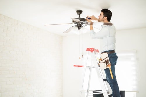 Électricien Septèmes-les-Vallons - Un artisan répare un ventilateur de plafond.