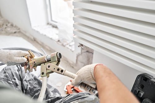 Marquette-lez-Lille - Un chauffagiste installe un radiateur