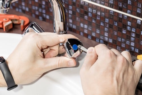 Plombier Mèze - Un artisan répare un robinet.