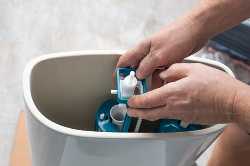 Plombier Montpellier - Un plombier installe des toilettes.