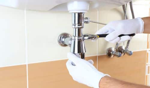Plombier Nice - Un plombier change le siphon d'un lavabo