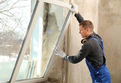 Vitrier Saint-Herblain - Un vitrier en uniforme installe une fenêtre