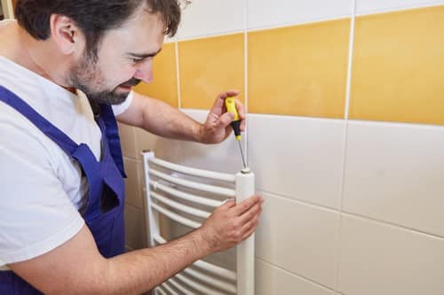 chauffagiste Courrières - un plombier chauffagiste installe un radiateur