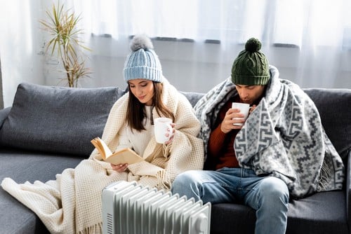 chauffagiste Fonsorbes - Un couple ont un bonnet et une polaire en intérieur.