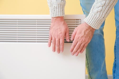 chauffagiste L'Isle-sur-la-Sorgue - Une personne se réchauffe les mains sur un radiateur.