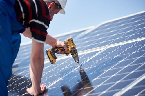 électricien Brignais - un ouvrier installe des panneaux de solaire